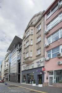 a tall building on a city street with buildings at Booking Rooms in Belgrade