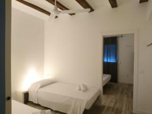 a white bedroom with a bed and a bath tub at NWT Central Station Apartments in Valencia