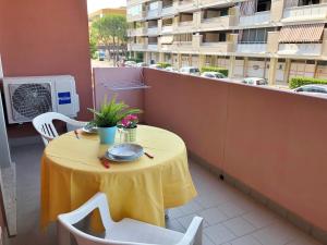 a yellow table and chairs on a balcony with a building at Residence Viale del Sole in Grado +2 photos