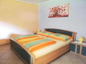 ツェーダーハウスにあるGästehaus Marianne Baierのベッドルーム1室(カラフルなシーツを使用した大型ベッド1台付)