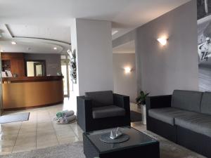 a living room with a couch and a table at Hotel Garni Max Zwo in Dingolfing