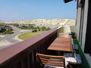 a balcony with two wooden tables and chairs on a building at Réf 542 Seignosse océan , bel appartement avec parking privatif, à 250m de la plage, 5 personnes in Seignosse