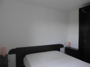 1 dormitorio con 1 cama y 2 velas rosas en Réf 542 Seignosse océan , bel appartement avec parking privatif, à 250m de la plage, 5 personnes en Seignosse