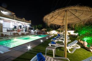 a swimming pool with lounge chairs and an umbrella at Cubo's Casa Rural Tirado in Alhaurín el Grande