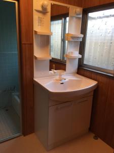 a bathroom with a sink and a mirror at Ibusiki Shizuka in Ibusuki