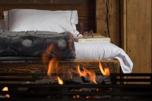 Hostellerie du Pas de l'Ours "Relais et Châteaux" في كرانس مونتانا: غرفة نوم بسرير ونار في موقد