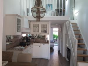 uma cozinha com armários brancos e uma escadaria em Maison Princesse em Port Leucate