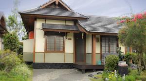 a small japanese house with a black roof at Villa Kota Bunga Ade Type Jepang - 0228 in Cibadak