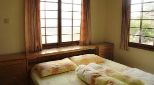 a bedroom with a bed and two windows at Villa Kota Bunga Ade Type Jepang - 0228 in Cibadak