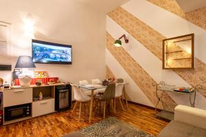 Merulana Suite Apartment في روما: غرفة معيشة مع طاولة وكراسي