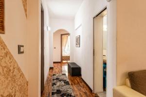 un corridoio con pareti bianche e una scala con uno sgabello di Merulana Suite Apartment a Roma