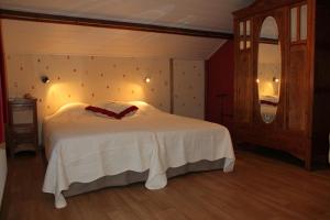 Un dormitorio con una cama blanca con un arco rojo. en B&B Sol Magnus, en Stavelot