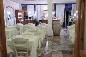 a dining room with white tables and chairs at Hotel Giuly in Torre del Lago Puccini