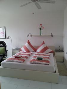 - un lit avec des oreillers rouges et blancs dans l'établissement Apartment Hagen Nähe TU Altstadt, à Dresde