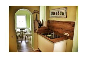 a kitchen with a sink and a table with a window at Ferienwohnung Storchennest in Volkach