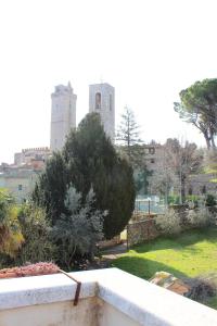 a view from the balcony of a building with two towers at Locanda La Mandragola in San Gimignano