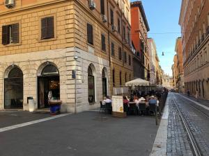 un grupo de personas sentadas en mesas en una calle de la ciudad en Hotel Termini, en Roma
