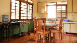 une cuisine avec une table, des chaises et une cuisinière dans l'établissement Villa Kota Bunga Ade Type Jepang - 0310, à Cikundul 11 autres photos