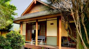 une petite maison avec des chaises sur une terrasse couverte dans l'établissement Villa Kota Bunga Ade Type Jepang - 0310, à Cikundul