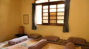 une chambre avec trois lits et une fenêtre dans l'établissement Villa Kota Bunga Ade Type Jepang - 0310, à Cikundul