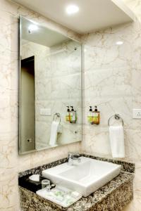 een badkamer met een wastafel en een spiegel bij Lemon Tree Hotel, Katra in Katra