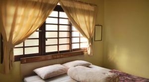 ein Bett in einem Schlafzimmer mit Fenster in der Unterkunft Villa Kota Bunga Ade Type Jepang - 0620 in Cibadak