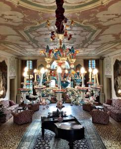 a living room with a chandelier and a room with couches at Hotel Villa Condulmer in Mogliano Veneto