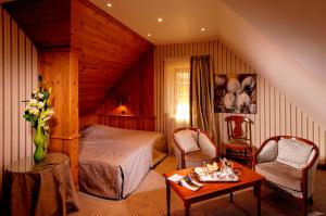 1 dormitorio con 1 cama, mesa y sillas en Hotel Restaurant L'Ami Fritz, en Ottrott