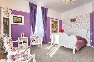 普拉的住宿－加里亞酒店，一间卧室设有紫色墙壁和白色家具