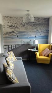 a living room with a couch and a painting of a pier at Sopot Apartament Kapitan J.Goyki in Sopot