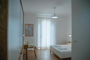 
a bedroom with a white bed and white walls at Mediterraneo Guesthouse in Giardini Naxos
