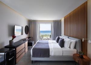 a hotel room with a bed and a view of the ocean at Neptune Luxury Resort in Mastichari