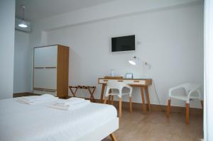 
a room with a table, chairs, and a television at Mediterraneo Guesthouse in Giardini Naxos
