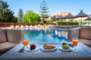 una mesa con comida y bebida junto a una piscina en Sunday Hotel, en Ialisos