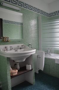 a green bathroom with a sink and a tub at La Ferme Ostalapia in Ahetze