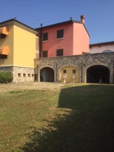 a large building with two entrances and a grass field at casa in campagna _LORI in Volta Mantovana