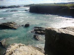 una vista de un cuerpo de agua con rocas en Apartamentos Fandin, en Ribadeo