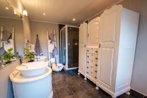 y baño con lavabo y ducha. en Singing Kettle Beach Lodge, en Keurboomstrand