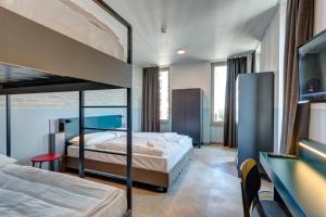 1 Schlafzimmer mit 2 Etagenbetten und einem TV in der Unterkunft MEININGER Milano Lambrate in Mailand