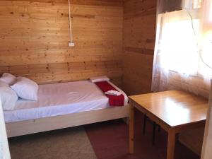 VorontsovkaにあるDom na bierieghu moriaの小さなベッドルーム(ベッド1台、テーブル付)