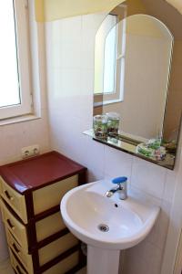 W łazience znajduje się umywalka i lustro. w obiekcie Подвійний котедж з терасою біля моря Совіньон w Odessie