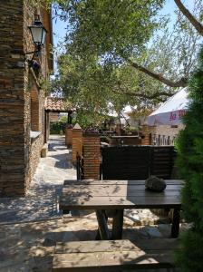 - une table de pique-nique en bois à côté d'un bâtiment dans l'établissement Casa Rural Peña Falcón, à Torrejón el Rubio