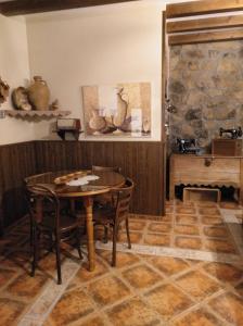 
a kitchen with a table, chairs, and a table cloth at Casa Rural Peña Falcón in Torrejón el Rubio

