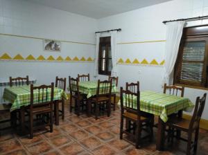 
a room with two beds and a table with chairs at Casa Rural Peña Falcón in Torrejón el Rubio
