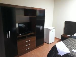 アスンシオンにあるResidencia Leones de Castillaのベッドルーム(テレビ付きの大型エンターテイメントセンター付)