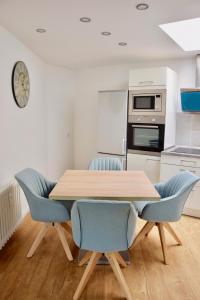 ブラウンラーゲにあるApartment der Entspannungのキッチン(木製テーブル、青い椅子付)