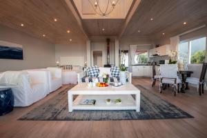 sala de estar con cama, mesa y cocina en Singing Kettle Beach Lodge, en Keurboomstrand