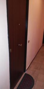 a brown door with a mat in a hallway at Residence Baia Blu Falcone in Falcone