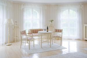 a white room with a table and chairs and windows at Pałac Brzeźno Spa & Golf in Oborniki Śląskie