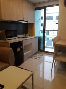 un salon avec une cuisine équipée d'un four micro-ondes dans l'établissement Arcadia Beach Resort By Dary, à Pattaya (sud) 20 autres photos